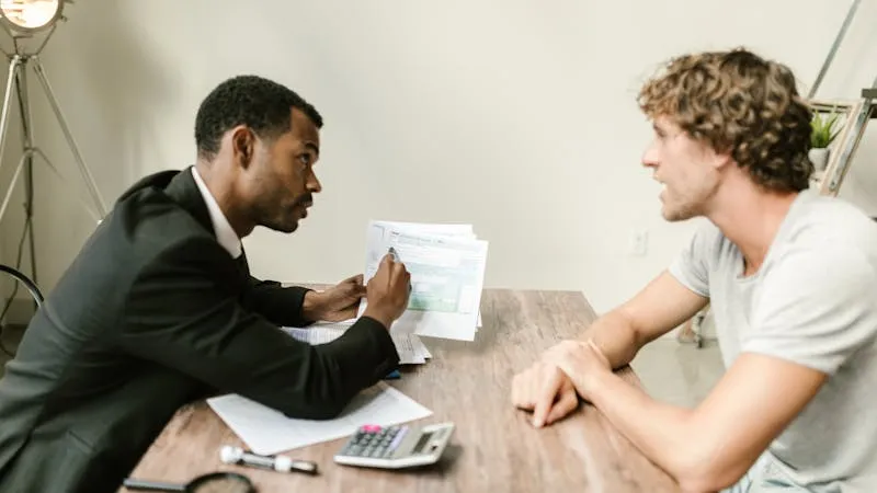 person meeting bank advisor reviewing mortgage documents at desk
